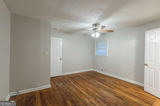 spare room with ceiling fan, dark wood-type flooring, and a textured ceiling