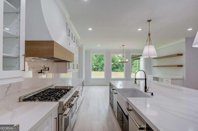 2626 Sardis Way, Buford, GA 30519 - kitchen with appliances with stainless steel finishes, light wood-style flooring, white cabinetry, premium range hood, and decorative light fixtures