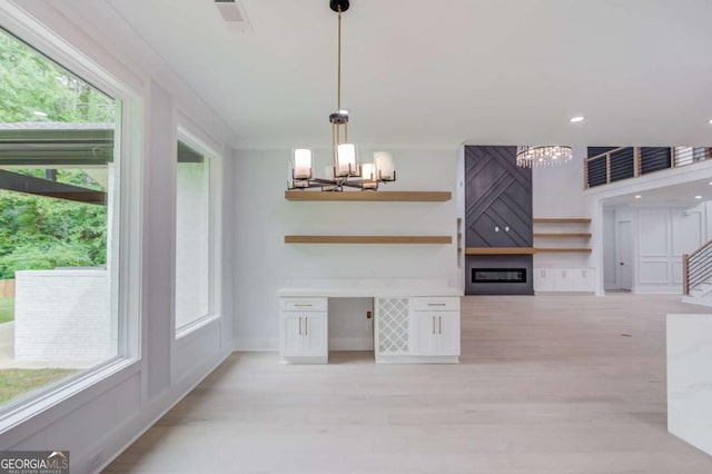 kitchen with white cabinetry, a wealth of natural light, pendant lighting, and light wood-type flooring