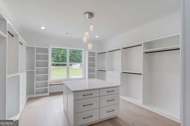 walk in closet with light hardwood / wood-style flooring