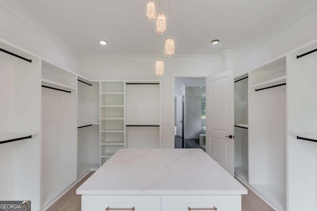 walk in closet with light hardwood / wood-style floors