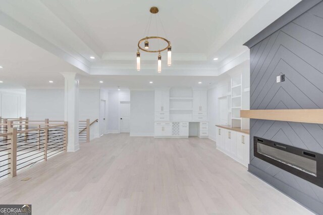 2626 Sardis Way, Buford, GA 30519 - unfurnished living room featuring crown molding, light wood-style flooring, recessed lighting, a raised ceiling, and decorative columns