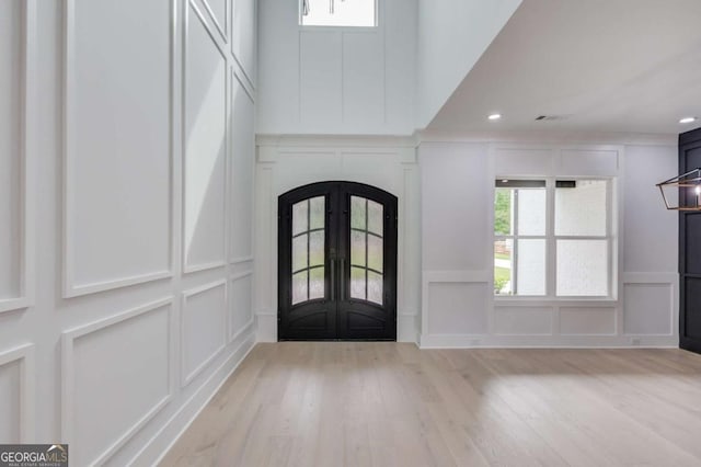 entryway featuring a healthy amount of sunlight, light wood-type flooring, and french doors