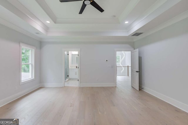 unfurnished room featuring light wood-type flooring, a raised ceiling, and ceiling fan