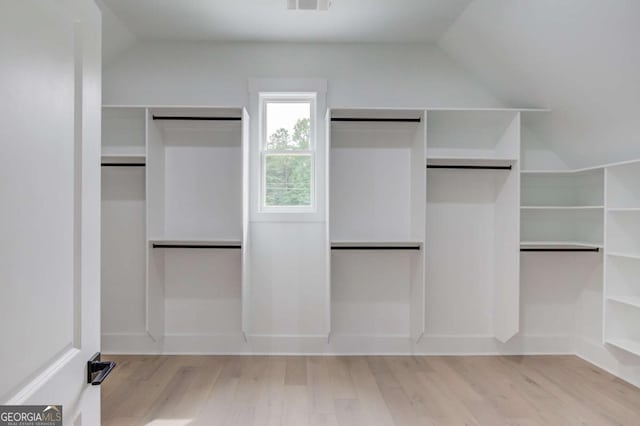 spacious closet with lofted ceiling and light hardwood / wood-style flooring