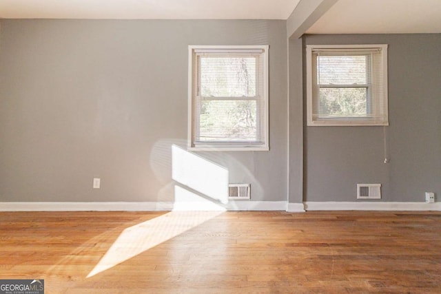 empty room featuring hardwood / wood-style floors and plenty of natural light