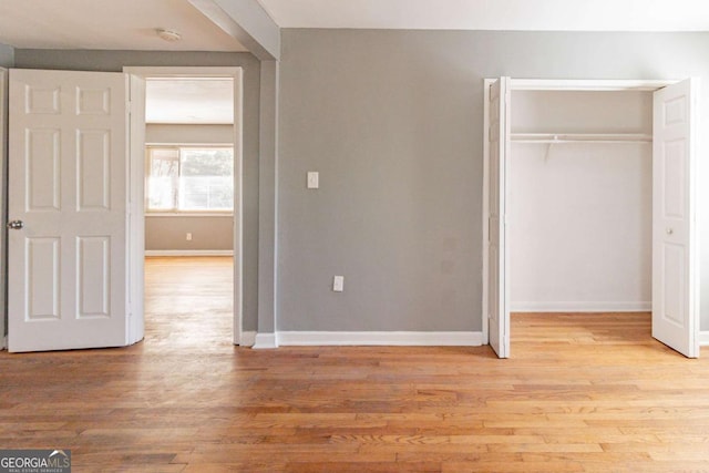 unfurnished bedroom featuring a closet and light hardwood / wood-style flooring