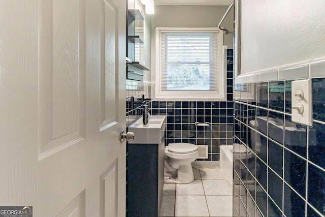 full bathroom with tile patterned floors, vanity, bathing tub / shower combination, tile walls, and toilet