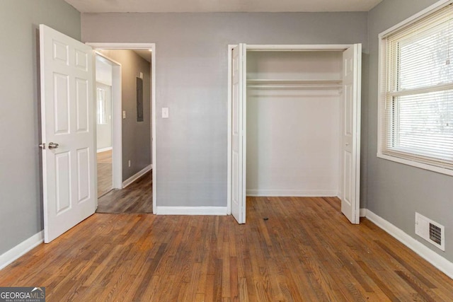 unfurnished bedroom with a closet and dark hardwood / wood-style flooring