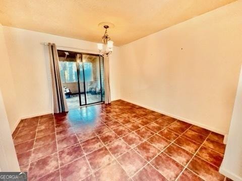 unfurnished room with a chandelier