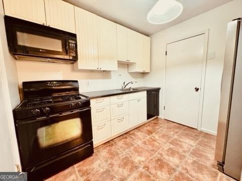 kitchen with sink, white cabinetry, and black appliances