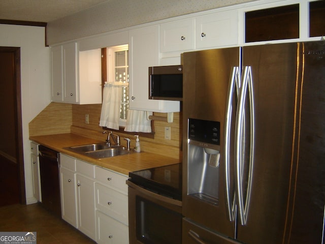 kitchen featuring backsplash, white cabinetry, sink, and appliances with stainless steel finishes