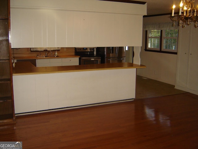 kitchen featuring dark wood-type flooring, white cabinets, sink, a notable chandelier, and stainless steel appliances