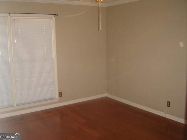 spare room featuring hardwood / wood-style flooring and ornamental molding