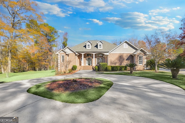 new england style home with covered porch and a front lawn