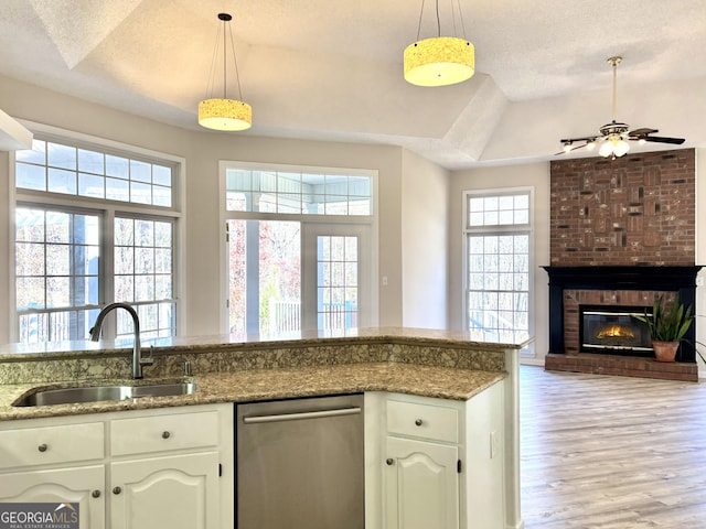 kitchen featuring dishwasher, a textured ceiling, a wealth of natural light, and sink