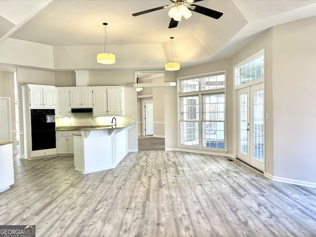 kitchen featuring french doors, double oven, pendant lighting, light hardwood / wood-style floors, and white cabinets