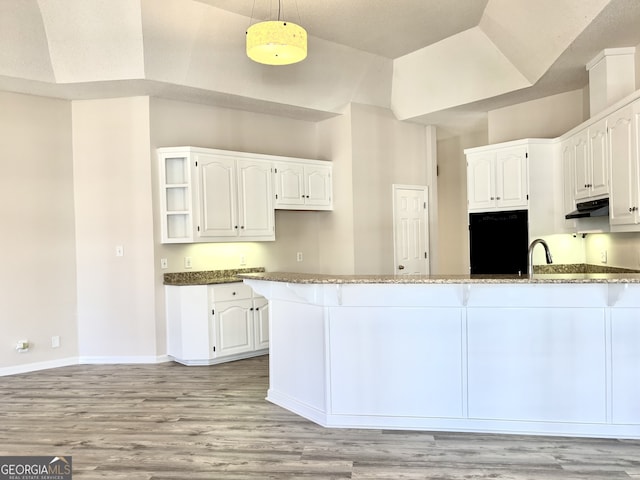 kitchen with dark stone countertops, white cabinetry, pendant lighting, and black fridge