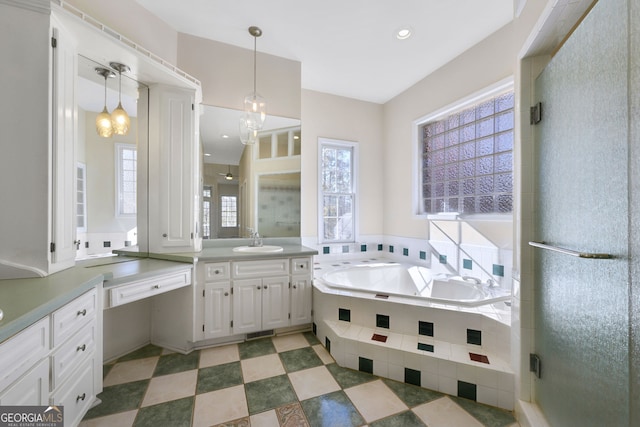 bathroom featuring vanity, independent shower and bath, and an inviting chandelier