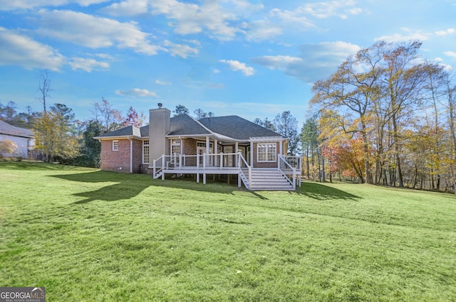 rear view of house featuring a lawn and a wooden deck