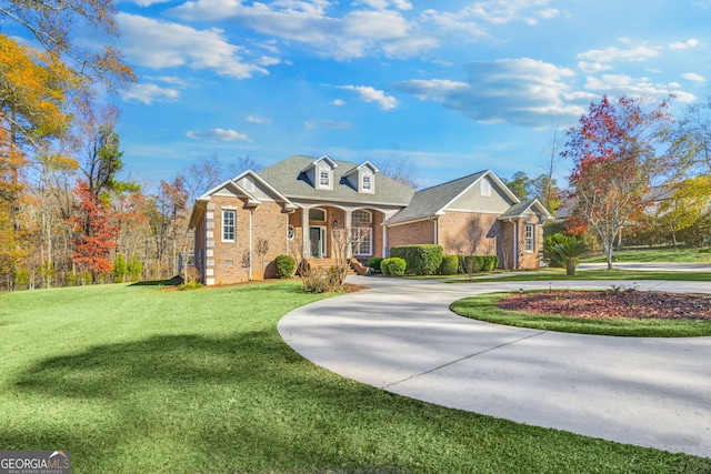 cape cod home featuring covered porch and a front yard