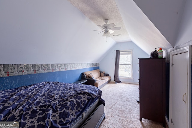 bedroom featuring a textured ceiling, ceiling fan, light carpet, and vaulted ceiling