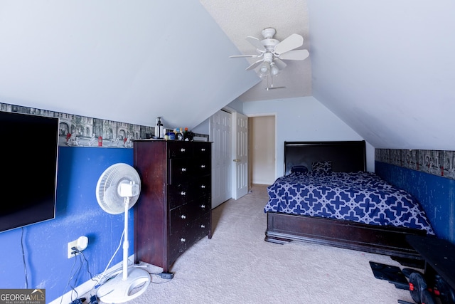 unfurnished bedroom featuring ceiling fan, light colored carpet, and vaulted ceiling