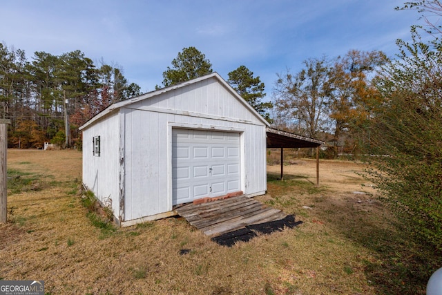 garage featuring a carport and a yard