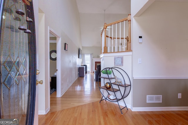 entryway featuring a fireplace, a high ceiling, and hardwood / wood-style flooring