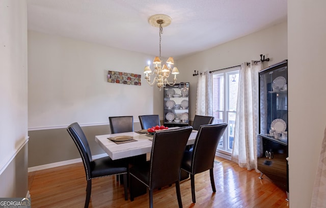 dining area featuring hardwood / wood-style flooring and a chandelier