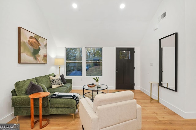 living room with light hardwood / wood-style floors and lofted ceiling