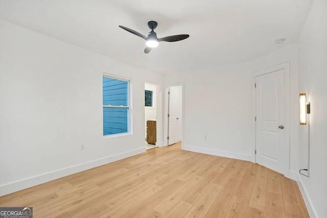 empty room with ceiling fan and light hardwood / wood-style floors