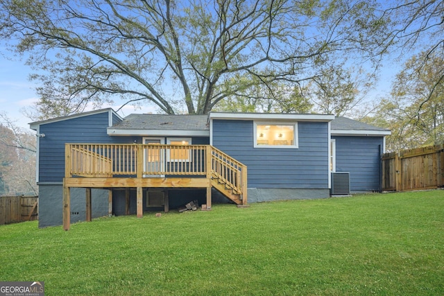 rear view of property with a yard and a wooden deck