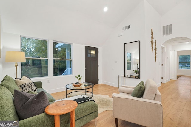 living room featuring light hardwood / wood-style floors and high vaulted ceiling