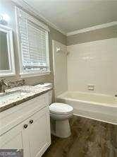 full bathroom with crown molding, vanity, shower / bath combination, and toilet