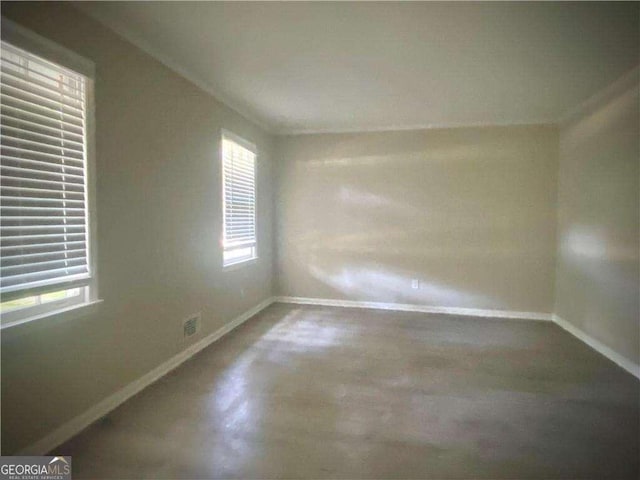 spare room with a wealth of natural light and concrete floors