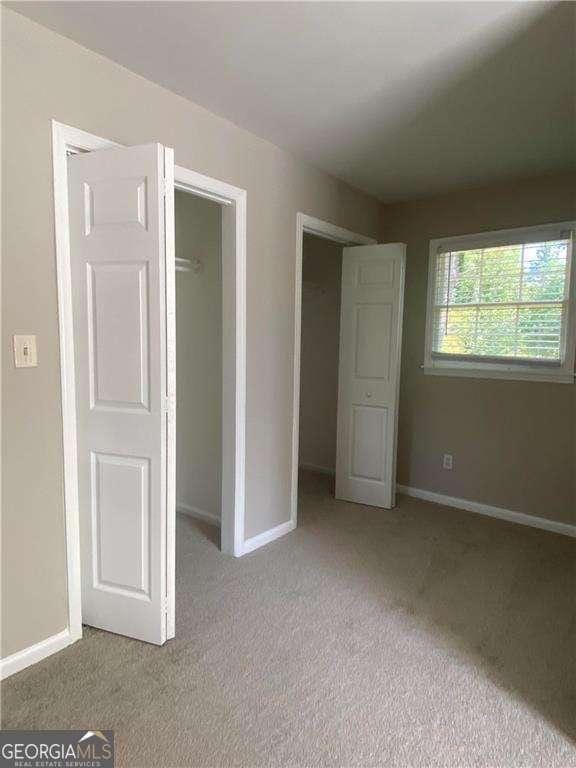 unfurnished bedroom featuring light carpet and a closet