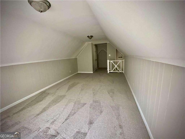 bonus room with carpet flooring and vaulted ceiling