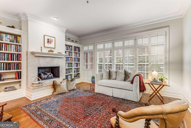 living room with hardwood / wood-style floors, built in shelves, and ornamental molding