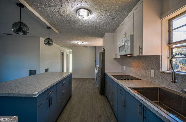 kitchen with dark hardwood / wood-style flooring, stainless steel fridge, sink, and blue cabinets