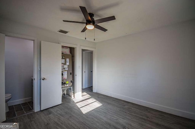 unfurnished bedroom with ceiling fan and dark wood-type flooring