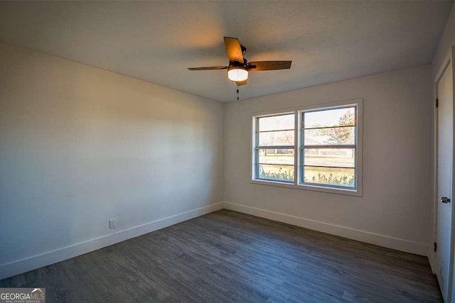 unfurnished room with ceiling fan and dark wood-type flooring