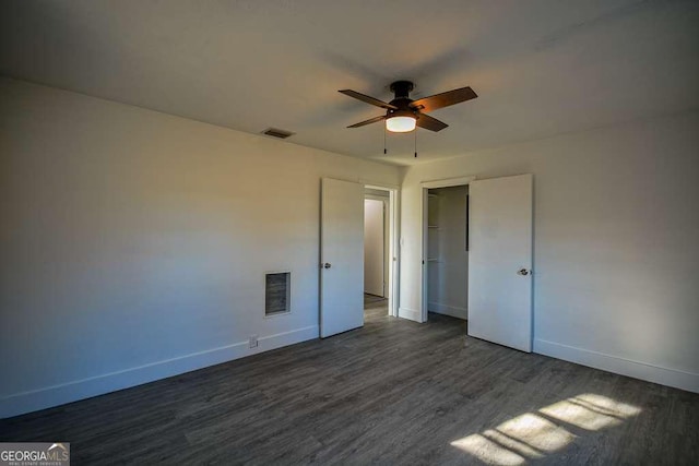 unfurnished bedroom featuring ceiling fan, a closet, and dark wood-type flooring