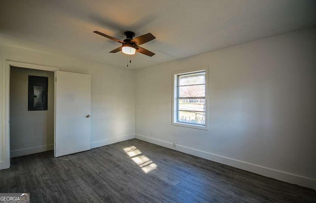 unfurnished room with ceiling fan, dark wood-type flooring, and electric panel