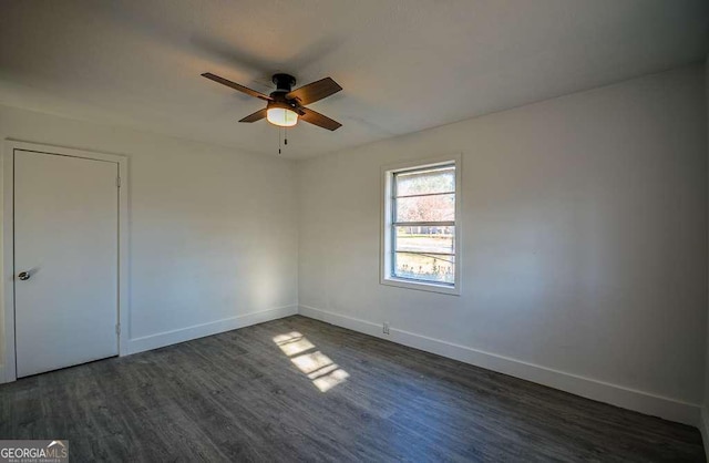 spare room featuring ceiling fan and dark wood-type flooring