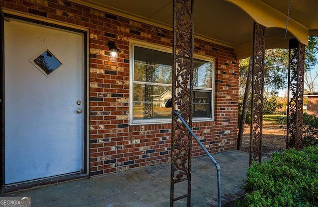 view of exterior entry featuring covered porch