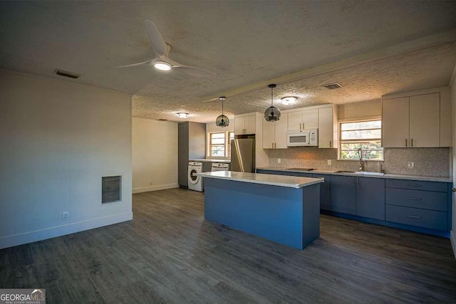 kitchen featuring dark hardwood / wood-style flooring, stainless steel fridge, a textured ceiling, decorative light fixtures, and a kitchen island