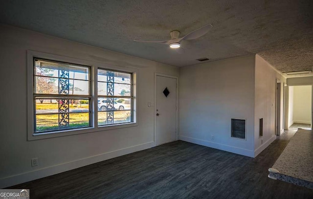 empty room featuring ceiling fan, dark hardwood / wood-style flooring, and a textured ceiling