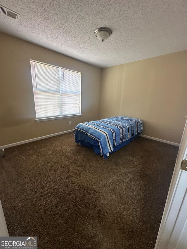 carpeted bedroom featuring a textured ceiling