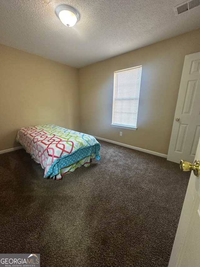 carpeted bedroom featuring a textured ceiling